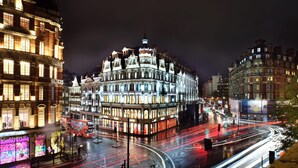A historic building with multiple stories and ornate architecture, located at a busy intersection with visible traffic.