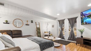 A modern bedroom with a bed, a sofa, a desk, and a TV. - Spacious 5-bedroom house in welcoming Manhattan (Manhattan)