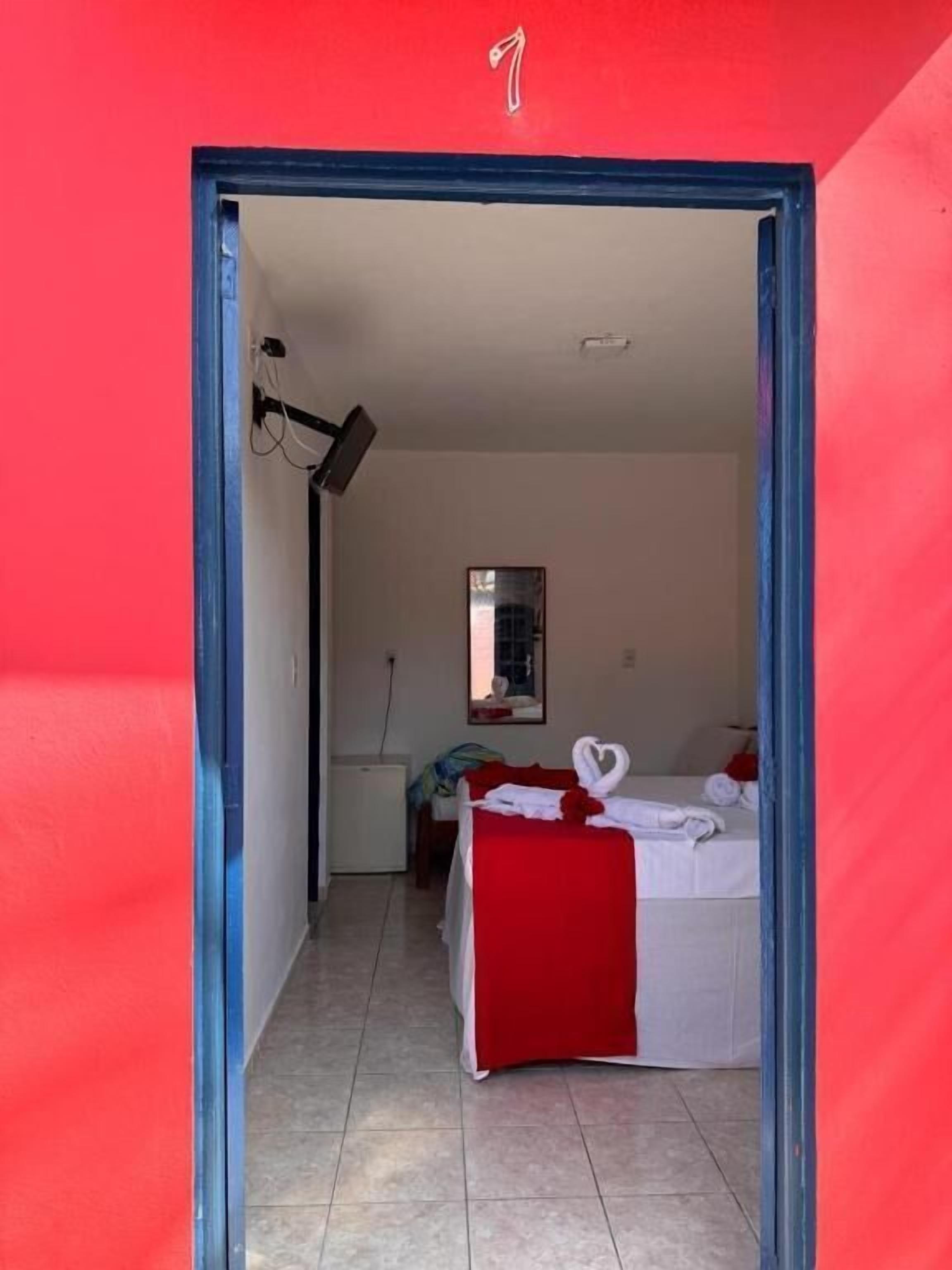 Una habitación con cama, un escritorio pequeño y un espejo en la pared.