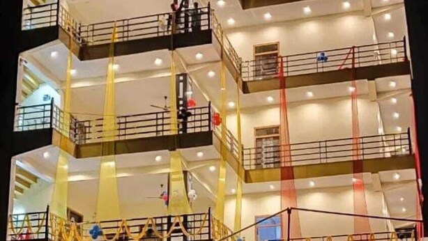 Un hotel de varios pisos con balcones, un atrio central y detalles decorativos.