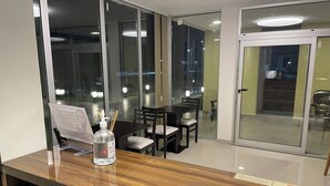 Un comedor moderno con una mesa de madera, sillas y un separador de vidrio.