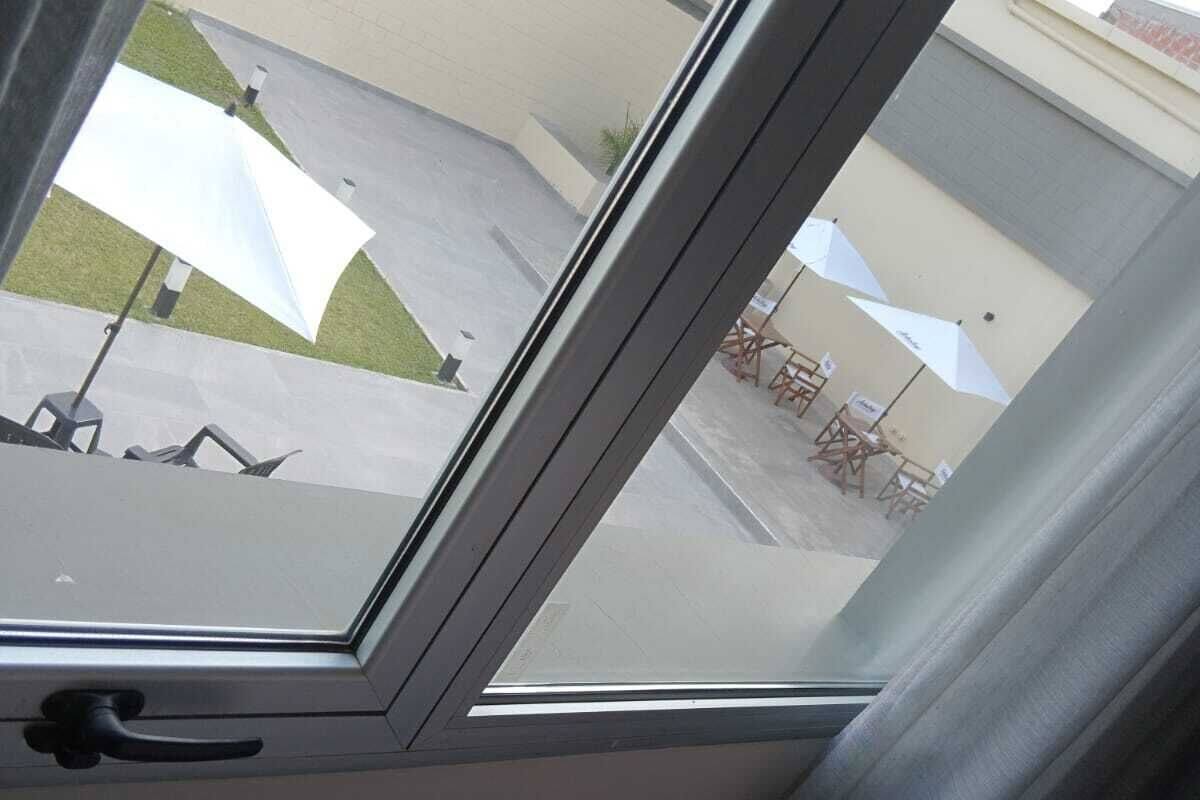 A window with a view of an outdoor patio area with umbrellas and seating.