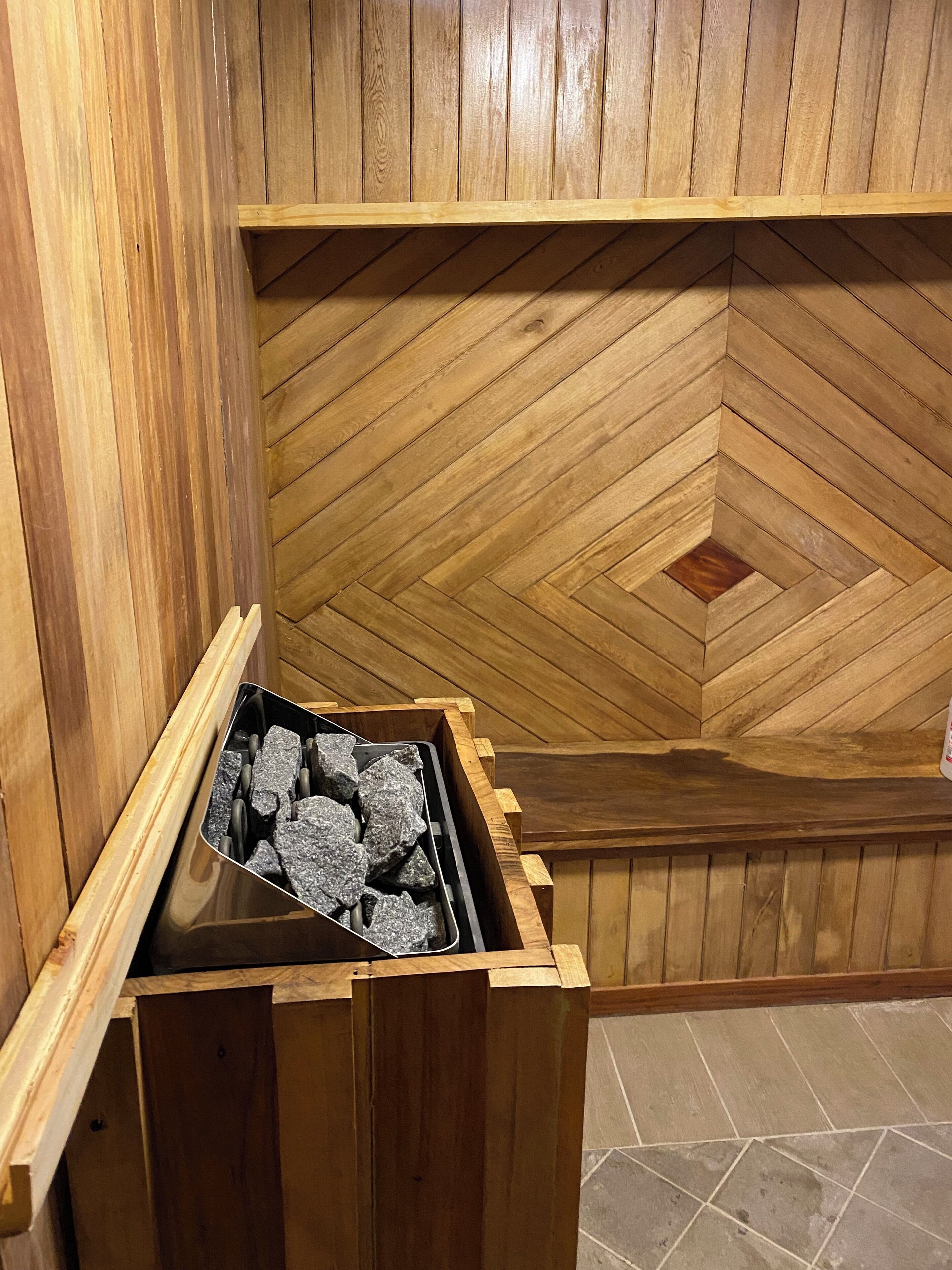 Una sauna con paredes de madera y un suelo con diseño de espiga.