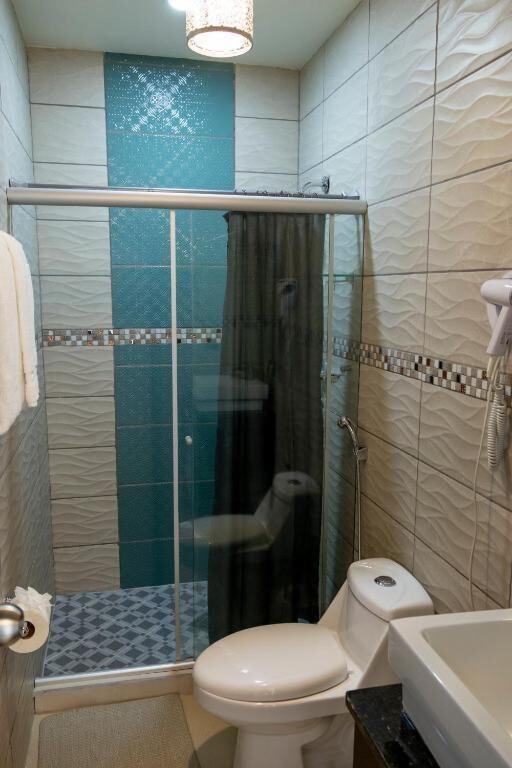 A bathroom with a glass-enclosed shower, a toilet, and a bathtub.
