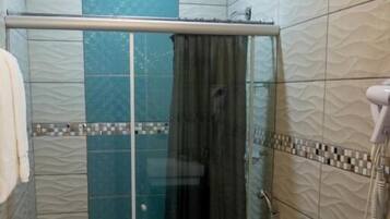 A bathroom with a glass-enclosed shower, a toilet, and a bathtub.