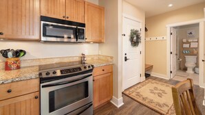 A kitchen with wooden cabinets, a microwave, a stove, and a sink. - Luxury 1-bedroom ski in/ski out condo in lovely Granby Ranch (Granby)