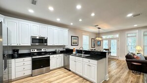 A modern kitchen with white cabinets, stainless steel appliances, and a black countertop. - Labor Day Just Opened! | Seacrest Beach | Sleeps 13 (Inlet Beach)