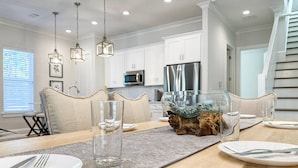 A dining area with a wooden table set for four, including plates, cutlery, and glasses.