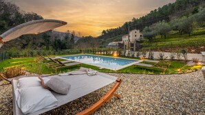 Ein Poolbereich mit Liegestuhl, einem kleinen Pool und Blick auf ein Gebäude im Hintergrund.