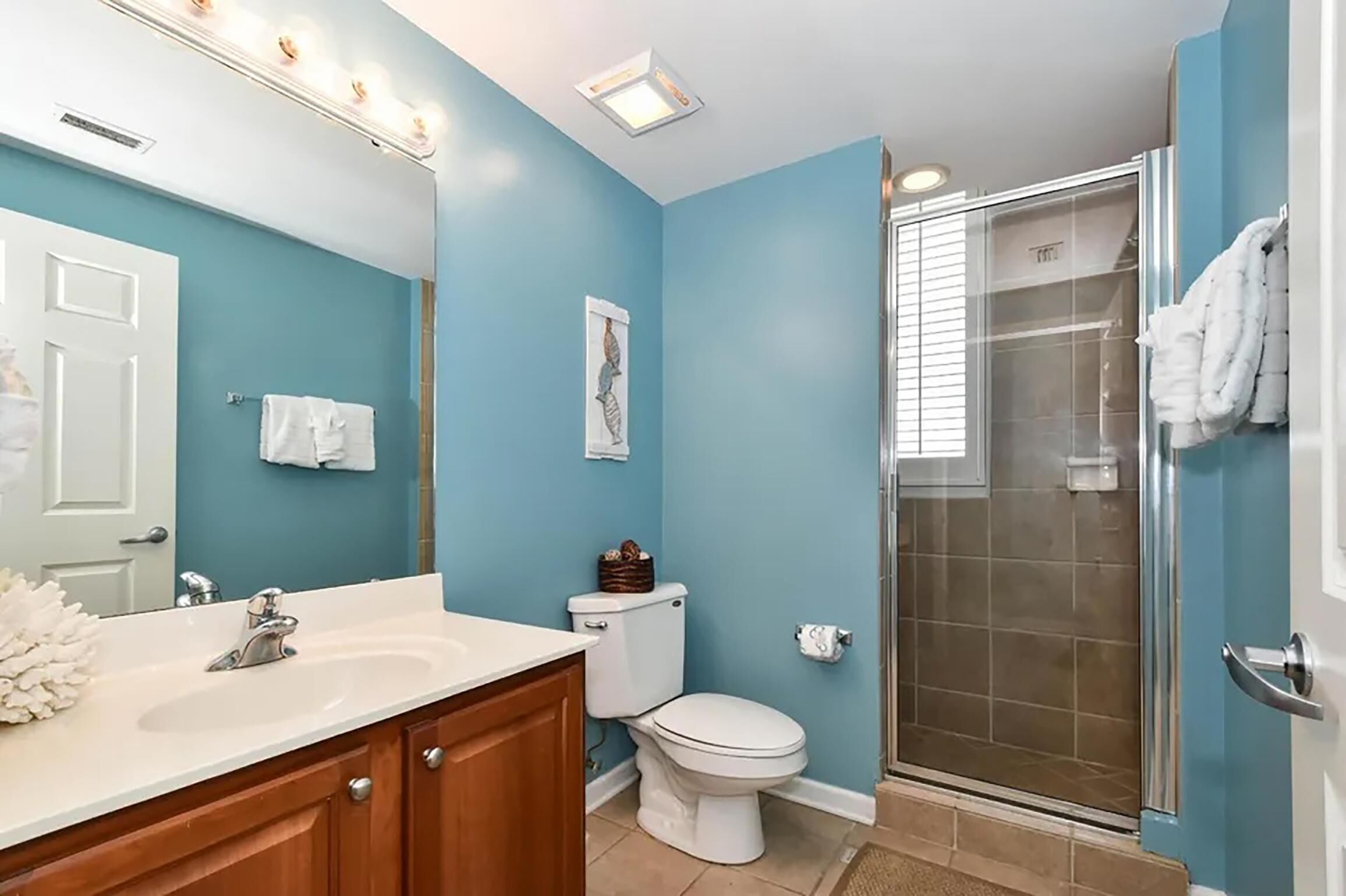 A bathroom with a white sink, a toilet, and a glass-enclosed shower.