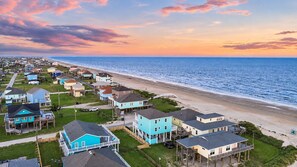 A coastal residential area with houses near the beach, featuring a mix of single and multi-story buildings, some with balconies and waterfront views. - 2nd Row Crystal Beach Home | Steps Away | Sleeps 18 (Crystal Beach)