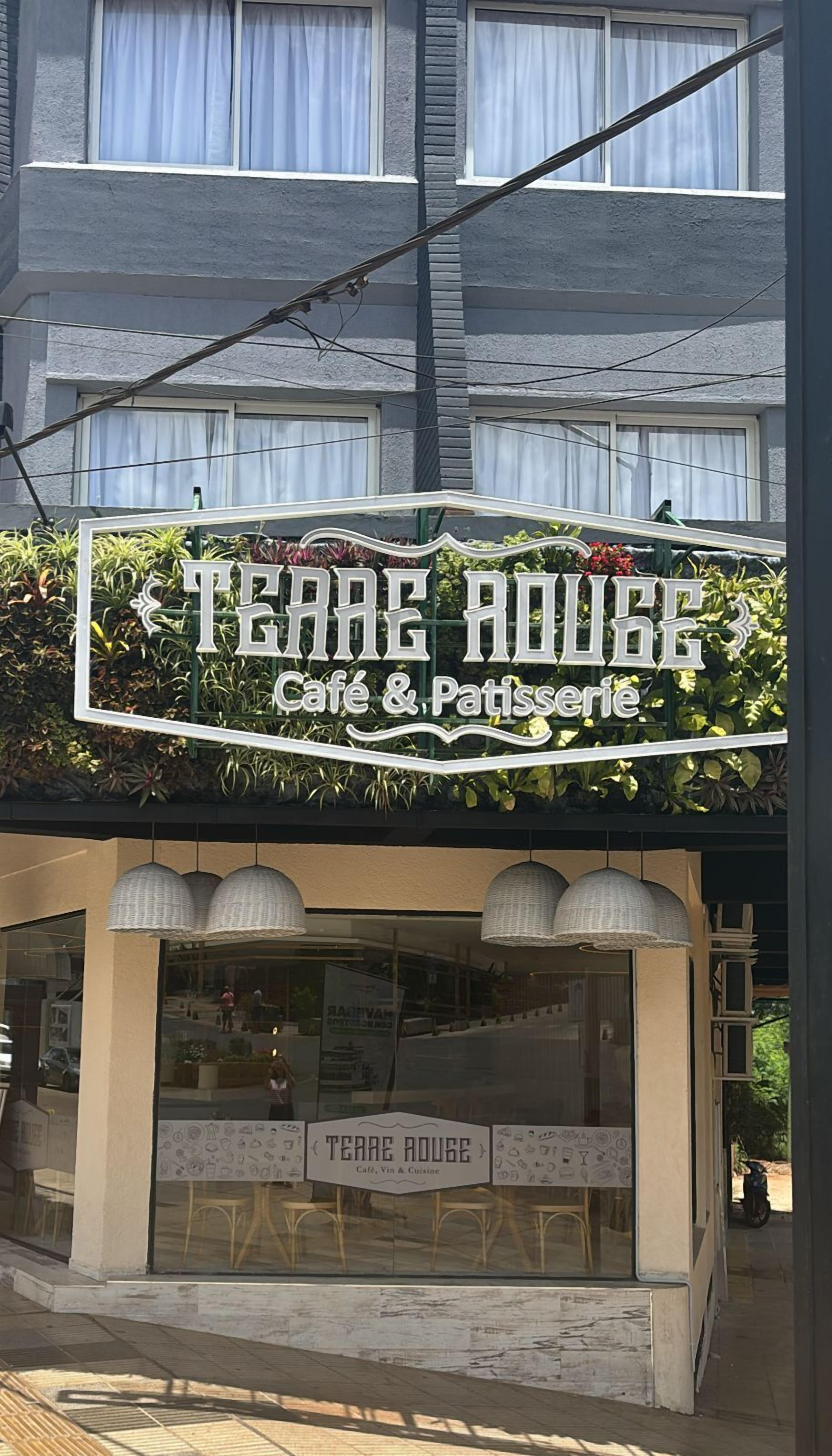 Un café appelé « Teahouse Café & Patisserie », avec une enseigne et une devanture en verre.