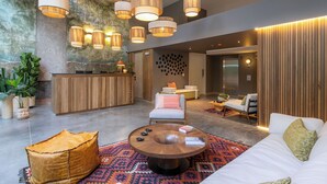 A modern lobby with a reception desk, seating area, and a large window. - Landmark Hotel (Medellín)
