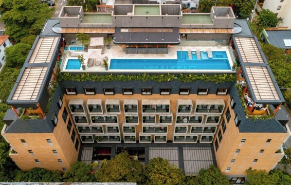 A multi-story building with a rooftop pool and outdoor seating area. - Landmark Hotel (Medellín)