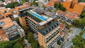A multi-story building with a rooftop pool, balconies, and a mix of residential and commercial spaces. - Landmark Hotel (Medellín)
