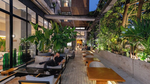 An outdoor café with seating and large plants. - Landmark Hotel (Medellín)