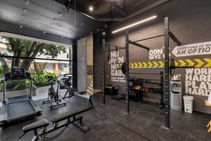 Ein Fitnessstudio mit Trainingsgeräten, motivierenden Wandbildern und Blick ins Freie.