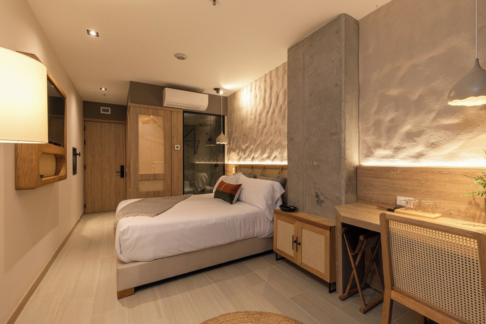 A modern bedroom with a bed, bedside tables, a desk, and a wardrobe.