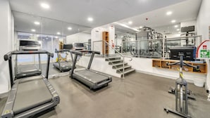 Un centre de remise en forme équipé de tapis de course, d’un appareil d’escalier et de machines de musculation.