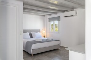 A bedroom with a bed, bedside lamp, and an air conditioning unit.