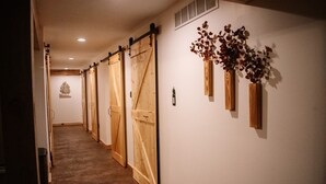 A hallway with wooden sliding doors and decorative vases on the wall. - Cozy 3-bedroom cabin in charming North East (North East)