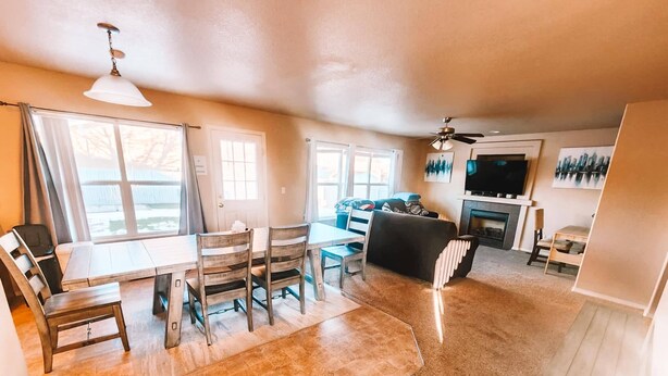 A spacious living area with a dining table, chairs, a sofa, and a fireplace. - Hot Tub, King Beds, Pet Friendly Close to I25 (Fountain)