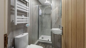 A modern bathroom with a glass-enclosed shower, a toilet, and a sink. - Fisherman's Nook - North East Escapes (Seahouses)