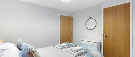 A bedroom with a bed, a bedside table, a wardrobe, and a ceiling light.