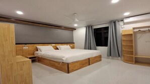 A modern bedroom with a wooden bed frame, a built-in wardrobe, and a ceiling fan.
