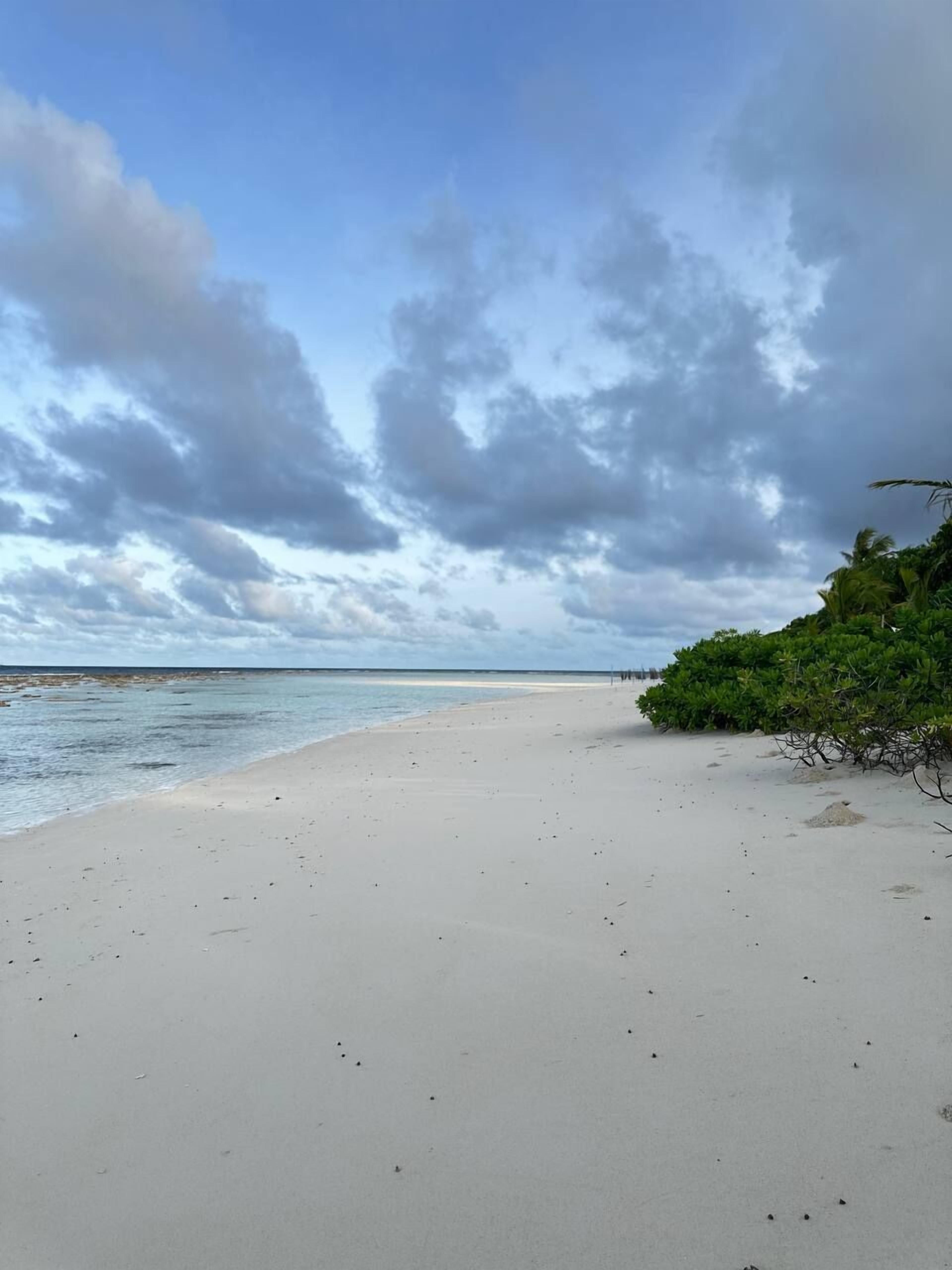 Una playa con cielos despejados y aguas tranquilas.