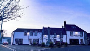 A two-story building with a pub sign, a large window, and a flagpole. - Lomond Hills Hotel & Health Club  (Cupar)