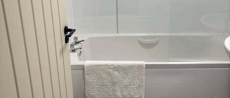 Un bagno con una vasca, un lavandino e un asciugamano appeso al muro.