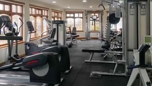 A gym with various exercise machines, large windows, and a bright interior. - Lomond Hills Hotel & Health Club  (Cupar)