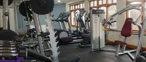 A gym with various exercise equipment including treadmills, weight machines, and free weights.