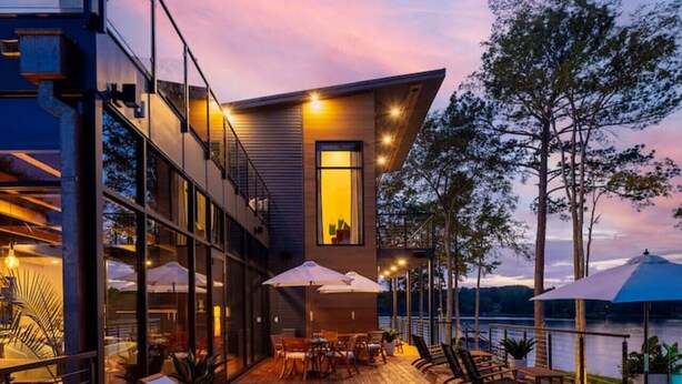 A modern house with a pool, outdoor seating, and a view of the water. - NEW! 151 House on Lake Oconee (Eatonton)
