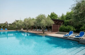A swimming pool with lounge chairs and a pergola. - AWS Holiday Homes - Indulge in Elegance (Dubai)