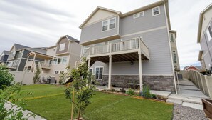 A two-story residential building with a covered patio and a small front yard.