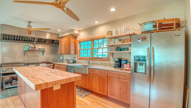 A modern kitchen with wooden cabinets, a stainless steel refrigerator, and a central island. - 4BR Bartlett. Near Attitash & Saco River. Sleeps 10+ (Bartlett)