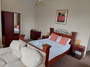 A neatly arranged bedroom with a wooden bed, a wardrobe, a bedside table, and a chair. - Y Pengwern (Blaenau Ffestiniog)
