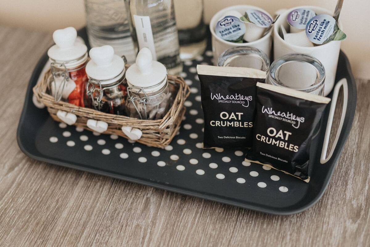 A tray with oat crumbles, jars, and bottles on a polka-dotted tray.