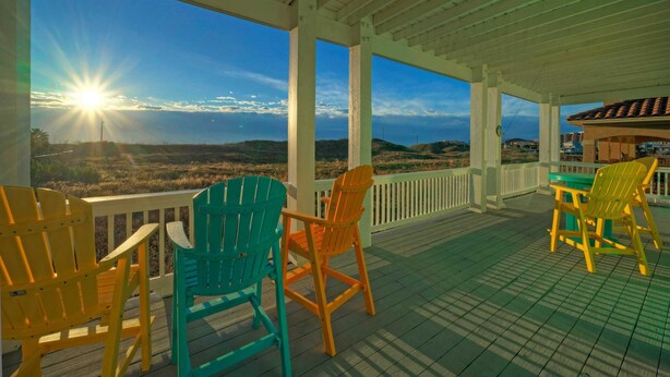 A covered outdoor area with a view of the landscape, featuring a table and chairs. - Coastal Soiree Ocean Views, Game Room, & Steps From Port Aransas Beaches (Port Aransas)
