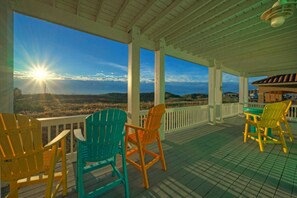 A covered outdoor area with a view of the landscape, featuring a table and chairs. - Coastal Soiree Ocean Views, Game Room, & Steps From Port Aransas Beaches (Port Aransas)