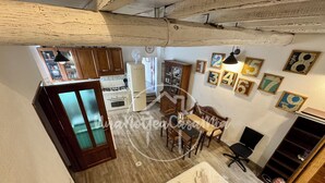 A compact room with a bed, a dining table, and a kitchenette. - La Scalinatella "UnaNotteaCasaMia" (SACROFANO)