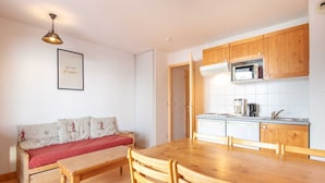 A compact living space with a kitchenette, a dining table, and a sofa. - Les Grizzlis N°27 - 2P6C (Saint-Sorlin-d´Arves)