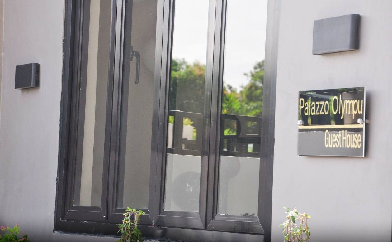 A building entrance with a sign reading "Palazzo Olimpico Guest House."
