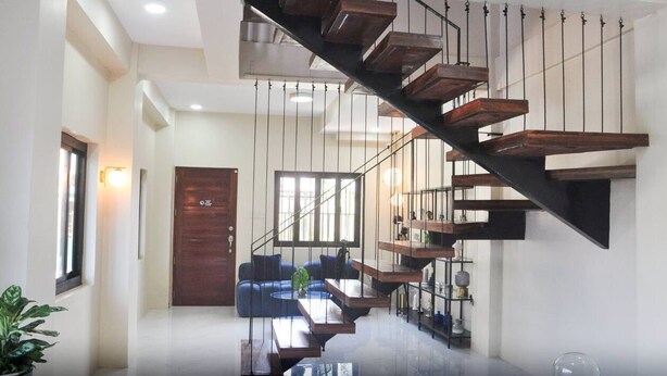 Ein modernes Interieur mit einer Holztreppe, einer Couch und einem Essbereich.