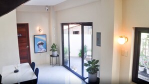 Ein modernes Interieur mit Essbereich, einer Tür zum Balkon und Topfpflanzen.