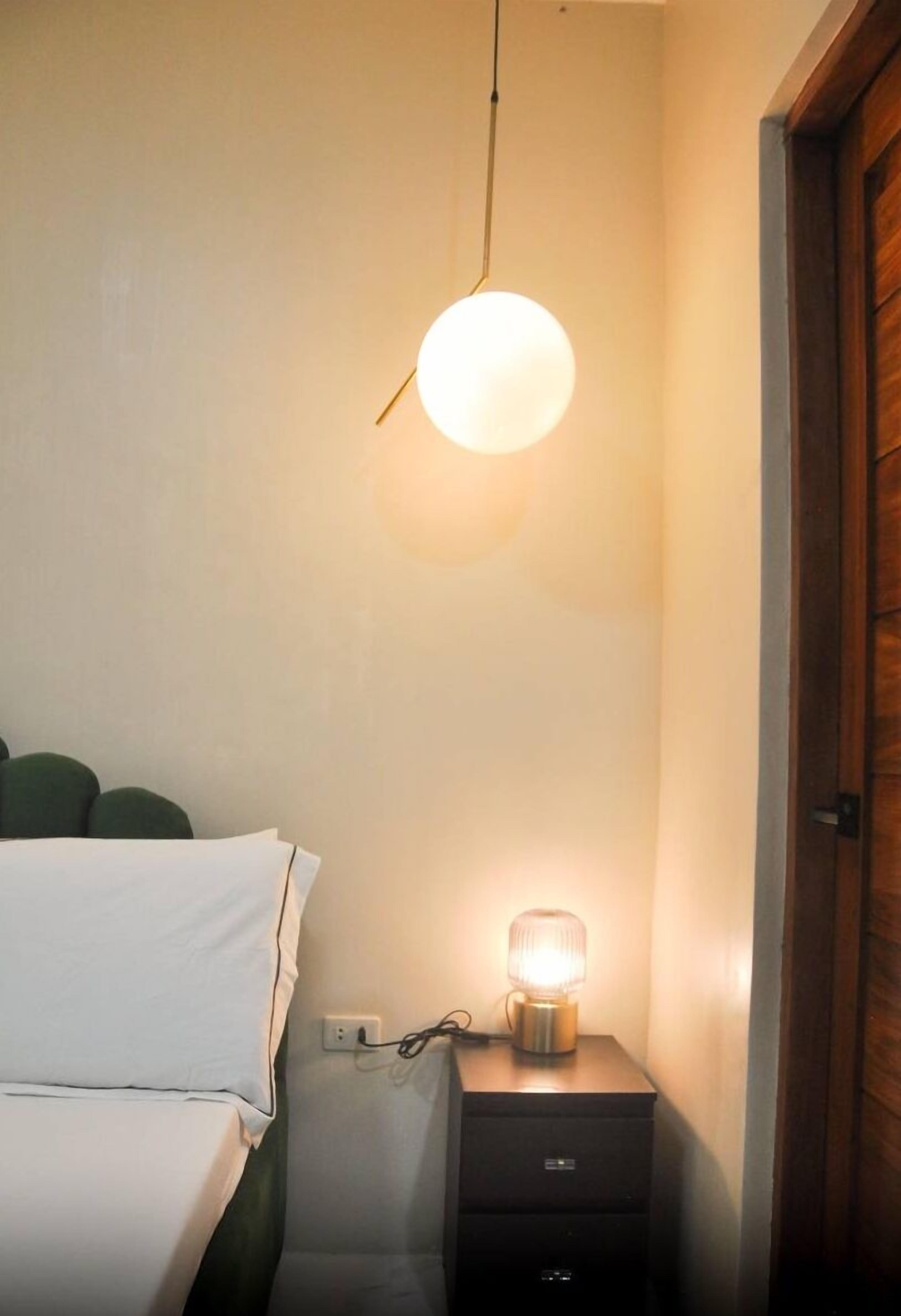 Une chambre à coucher avec un lit, une table de chevet avec une lampe et une porte en bois.