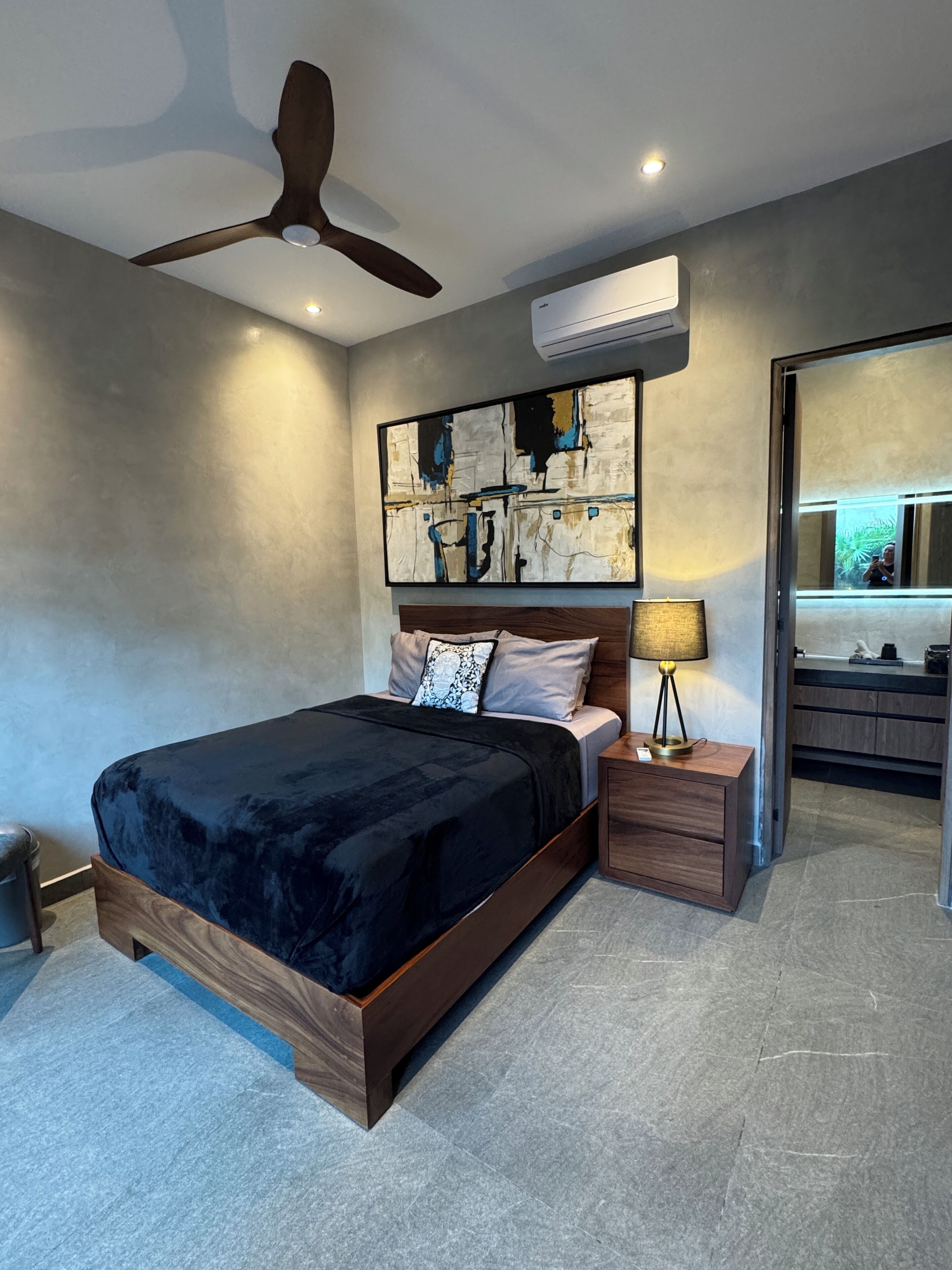Ein modernes Schlafzimmer mit Bett, Nachttisch und Deckenventilator.