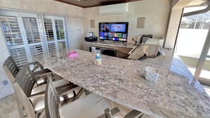 A kitchen with a granite countertop, stainless steel appliances, and a ceiling fan. - TOP FLORIDA's Villa Pelican Point (Cape Coral)